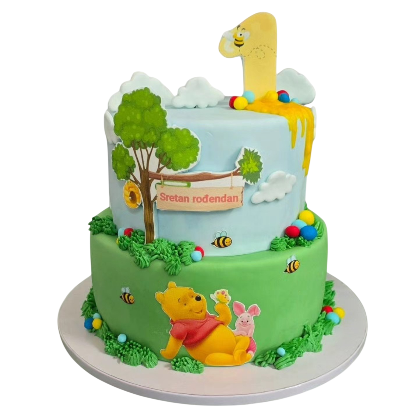 Personalizirana dječja rođendanska torta u Čakovcu s dekoracijom Winnie Pooh motiva, medvjedićem, pčelicama i natpisom sretan rođendan.
